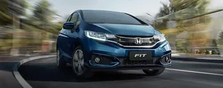 Auto Honda Fit andando en carretera con fondo en movimiento