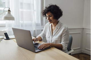 Mujer utilizando un computador para actividad laboral