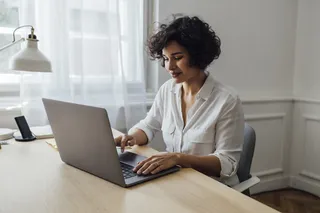 Mujer utilizando un computador para actividad laboral