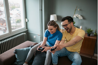 homem e mulher felizes jogando videogame em casa