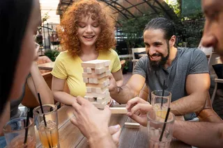 Amigos jugando jenga con bebidas