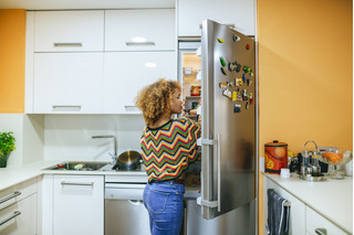 Mulher abrindo geladeira