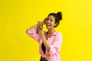 Una mujer sonriente se toma una foto con su smartphone