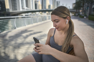 mujer usando auriculares in-ear