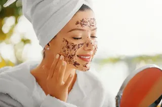 mulher passando esfoliante no rosto