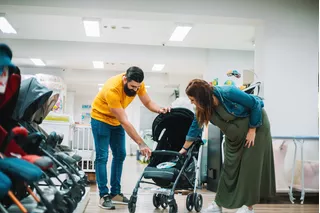 Casal escolhendo carrinho de bebê
