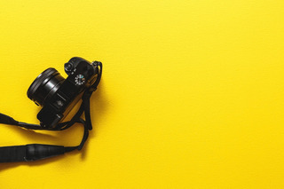 Cámara de fotos profesional negra sobre fondo amarillo
