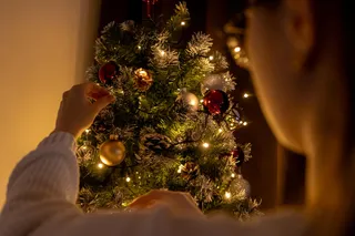 Una mujer decora un árbol de Navidad