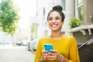 Mujer sonriente sosteniendo un celular