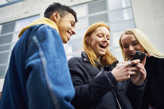 Tres amigos utilizando un celular