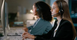 Mujeres utilizando auriculares con micrófono en el trabajo