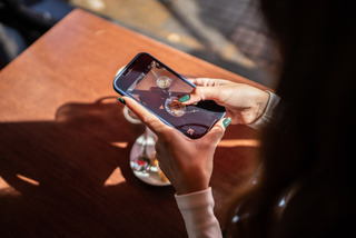 Una mujer toma una foto de su desayuno con su celular iPhone.
