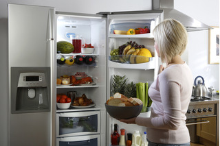 mulher guardando alimento na geladeira