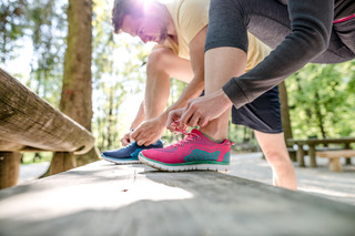 Hombre y mujer poniéndose una zapatilla deportiva