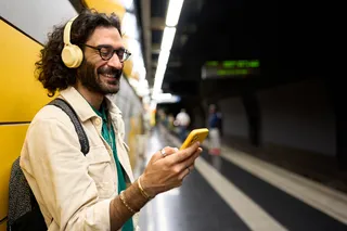 Homem ouvindo mĂșsica no metrĂŽ