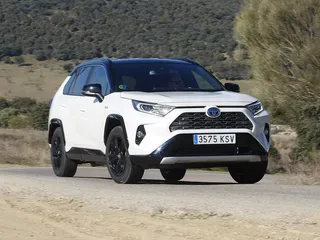 SUV Toyota RAV4 blanca al aire libre en entorno natural.