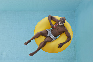 Homem com óculos de sol na piscina.