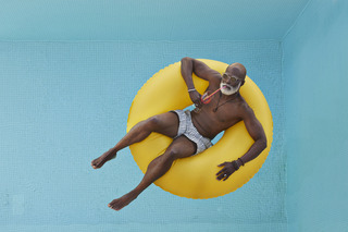 Homem com Ăłculos de sol na piscina.