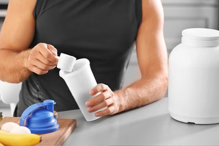 Pessoa preparando dose de Whey Protein
