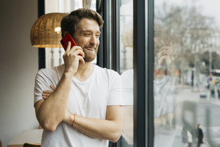 Un hombre sonriente hace una llamada con su celular Motorola
