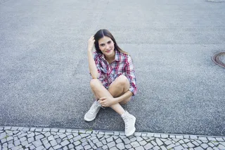Mujer sentada con zapatillas botitas