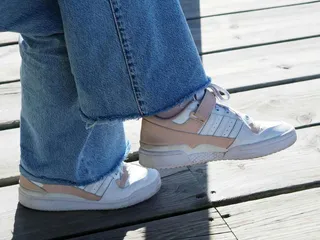 Persona con un outfit con jeans y tenis Adidas Forum.