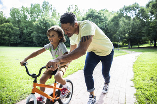 homem segurando filho em bicicleta