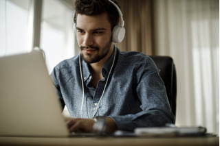 Hombre trabajando con laptop y escuchando música