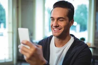 Hombre sonriente mirando el celular