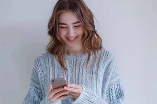 mujer sonriendo usando el celular