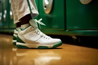 Hombre usando unos tenis blancos y verdes en un gimnasio.