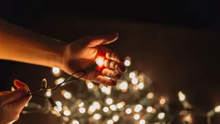 persona sosteniendo luces navideñas