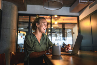 Persona utilizando su notebook en una cafetería