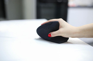 Pessoa usando mouse vertical ergonĂŽmico