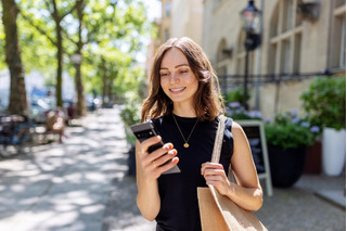 Mujer sonriente frente a su dispositivo movil