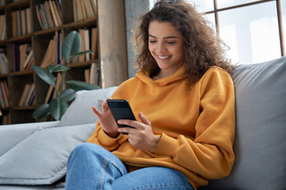 Una mujer joven utiliza su celular mientras descansa en el trabajo