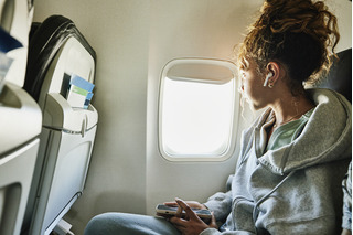 mujer usando auriculares en avión