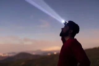 homem com lanterna de cabeça