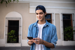 Un chico joven utiliza su celular Samsung.