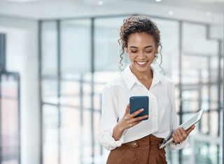 Una joven realiza tareas del trabajo en su celular