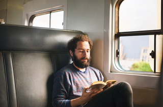 Hombre leyendo en un tren