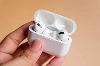 Persona que sostiene unos AirPods.