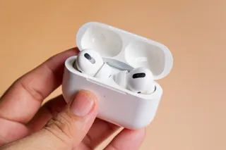 Persona que sostiene unos AirPods.