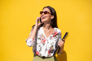 Mulher usa camisa estampada enquanto fala ao telefone celular