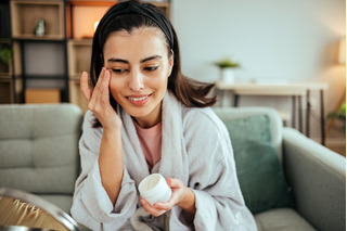 Mulher usando creme para olhos