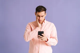Un hombre se sorprende al ver la pantalla de su celular