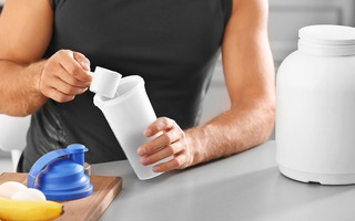 homem preparando shake proteico