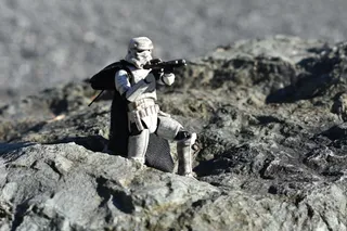 Figura articulada de un Stormtrooper apuntando con un bláster, sobre una roca