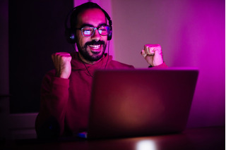 Hombre feliz jugando en el computador