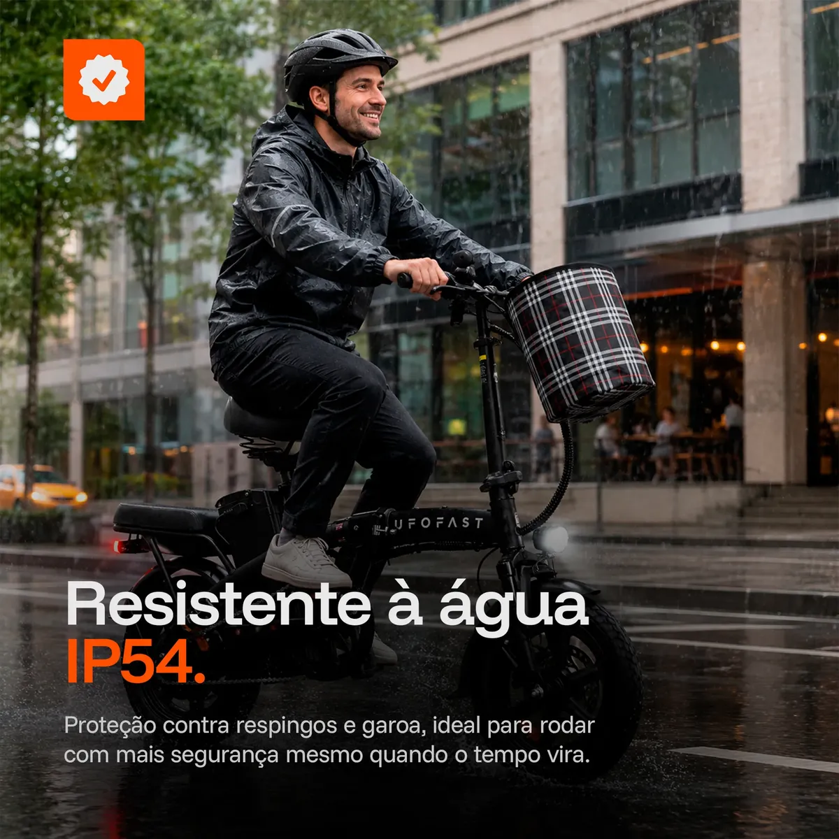 Homem andando de bicicleta elétrica UFOFAST MBE-F1L preta com cesta xadrez na chuva, demonstrando a resistência à água IP54 do produto em ambiente urbano.
